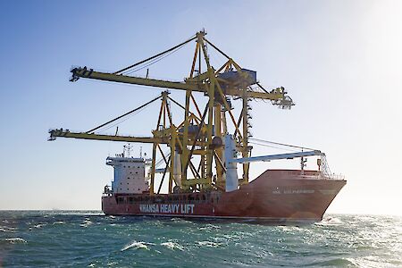 Hansa Heavy Lift vessel sails open hatch through the Northern Sea Route to deliver giant cranes